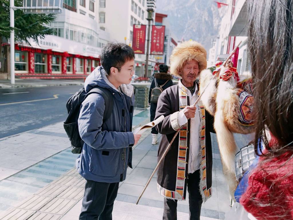 图为团队成员采访身穿当地特色民族服饰的居民 通讯员蒋宇翔提供